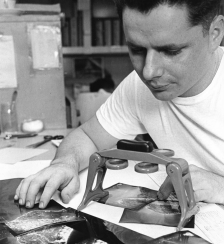 Photo intelligence 3rd Class Charles R. Pearson uses his stereoscopic equipment to analyze an aerial image of an enemy site in Vietnam.